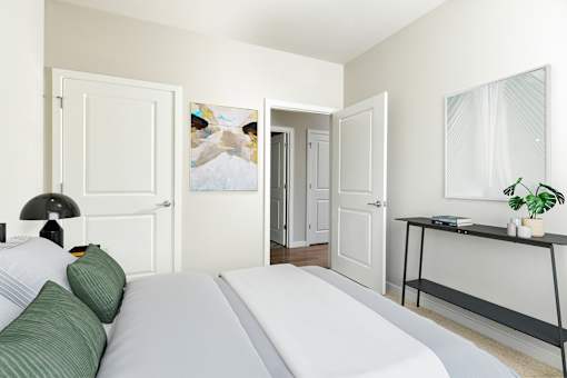 A bedroom with a white bed and a black shelf.