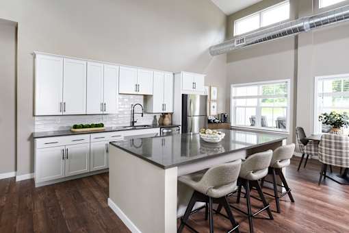 A kitchen with a large island and white cabinets.