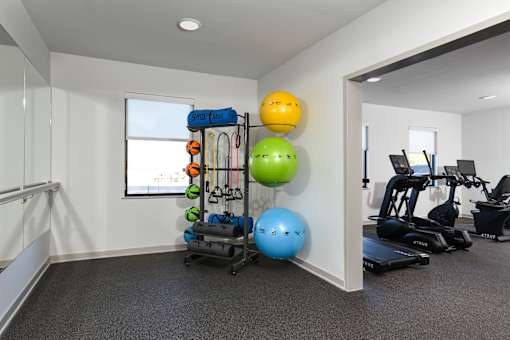 Dedicated workout area featuring yoga mats, resistance bands, and stability balls for stretching and bodyweight exercises.