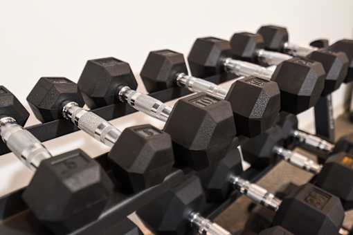Set of dumbbells arranged on a rack, offering a variety of weight options for strength training.