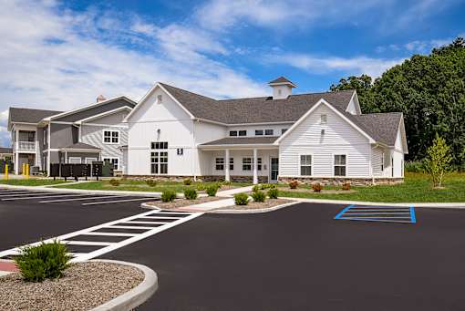 A white building with a parking lot in front.