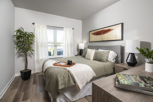 a bedroom with a large bed and a potted plant