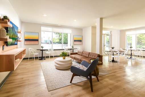 A community room with a brown couch and a white table.