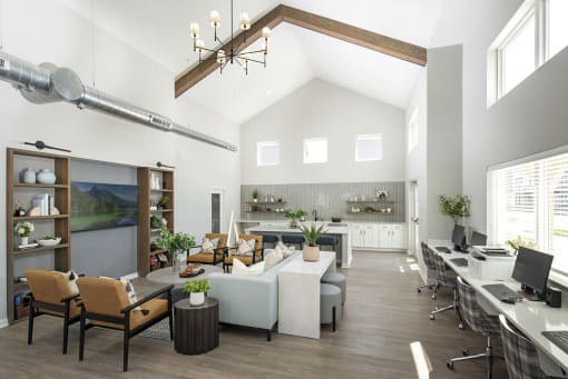 a large room with couches and chairs and a desk with a computer