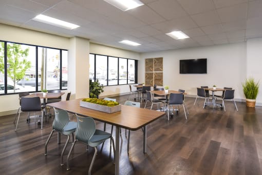 a large room with tables and chairs and a flat screen tv on the wall