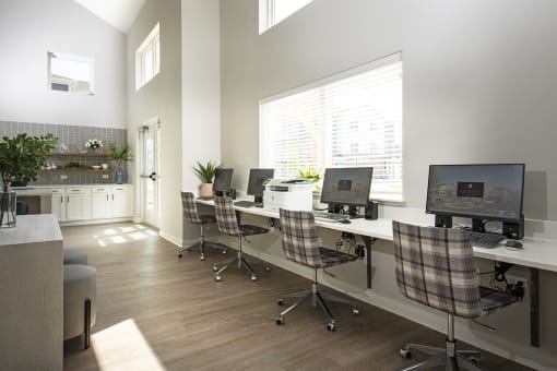 an office with computers and chairs and a large window