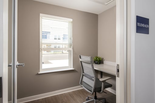 a desk and chair in a room with a window