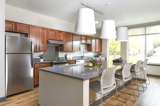 a kitchen with a large island and a stainless steel refrigerator