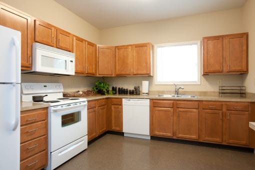 a kitchen with white appliances and wooden cabinets