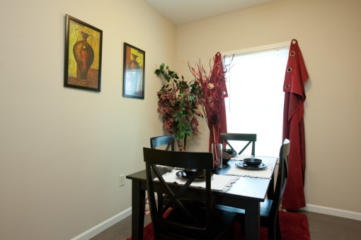 a dining room with a table and chairs and a window