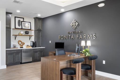 the lobby of villas at bonita farms with a desk and a computer