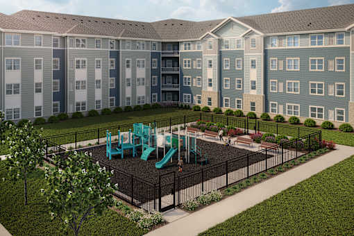 A playground with a green slide is surrounded by a black fence and a grassy area.