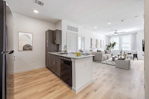 A modern kitchen with a white island and wooden floors.