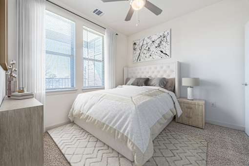 A bedroom with a large bed and a ceiling fan.