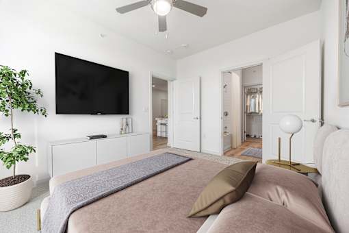 A bedroom with a large bed and a flat screen TV mounted on the wall.