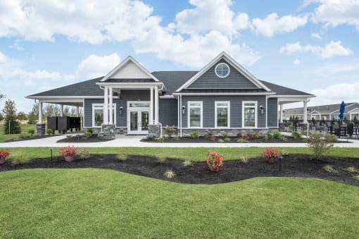 the front of a house with a lawn and a driveway