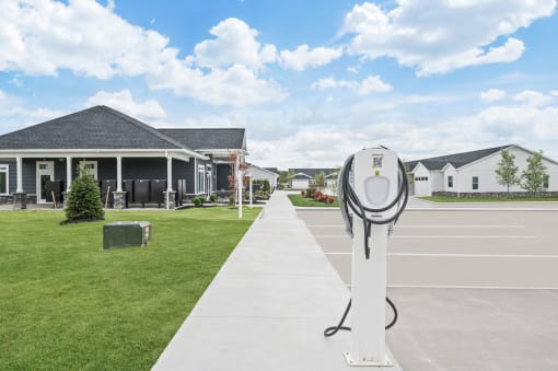 a EV charger in the middle of a sidewalk in front of a house