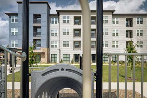 A playground with a slide in front of apartment buildings.