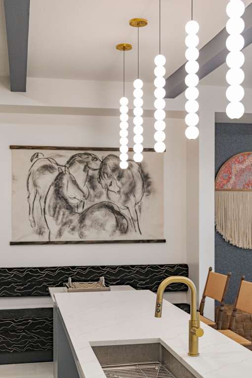 A kitchen with a sink and a painting on the wall.