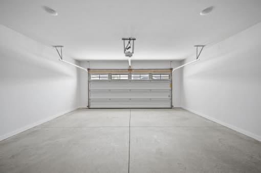 an empty garage with a white wall and a gray garage door