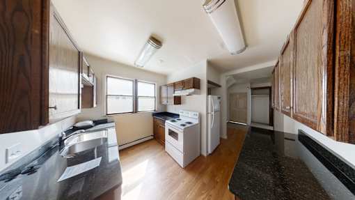 A kitchen with white appliances and wooden cabinets.