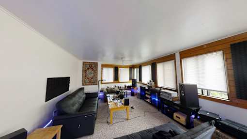 A living room with a black couch and a coffee table.