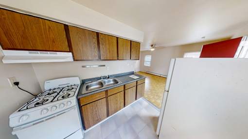 A kitchen with a white stove and wooden cabinets.