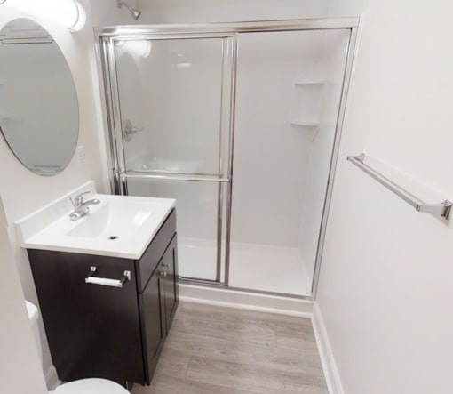 A bathroom with a toilet, sink, and shower.