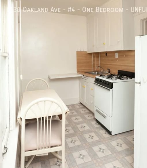 A kitchen with a white chair and a white stove.