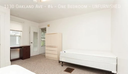 A bedroom with a bed, dresser, and wardrobe in an unfurnished apartment.