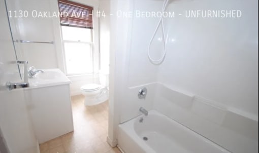A white bathroom with a tub, toilet and sink.
