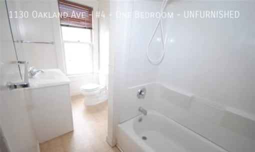 A white bathroom with a tub, toilet and sink.