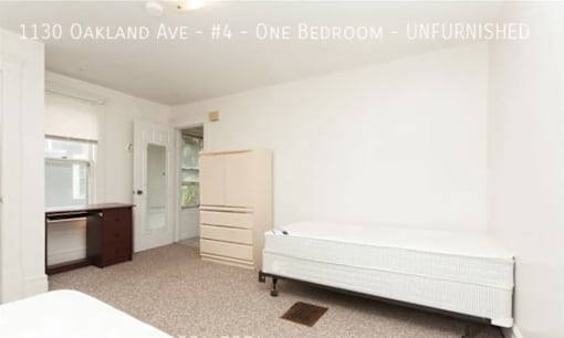 A bedroom with a bed, dresser, and wardrobe in a property located at 1130 Oakland Ave, unit #4.