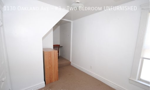 A room with a white wall and a brown box on the floor.