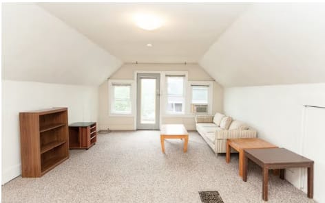 A living room with a couch, coffee table, and bookshelf.