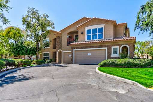 A large house with a driveway in front.