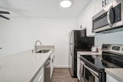 A modern kitchen with a black refrigerator, stove, and microwave.