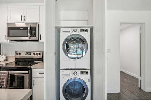 A modern kitchen with a washer and dryer built into the cabinetry.