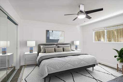 A bedroom with a large bed and a ceiling fan.