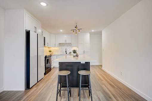 A kitchen with a bar stool and a counter.