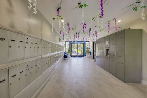 A hallway with white lockers on the left and green lockers on the right with hanging decorations.