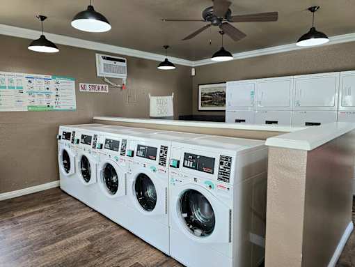 A row of white washing machines in a laundromat.