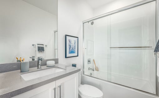 A bathroom with a toilet, sink, and shower.