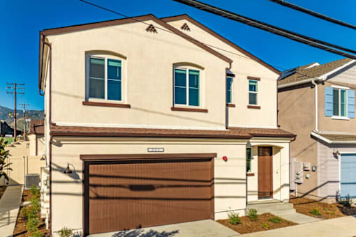 A two-story house with a brown garage door.