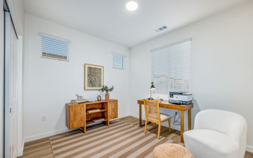 A room with a desk, chair, and a cabinet.