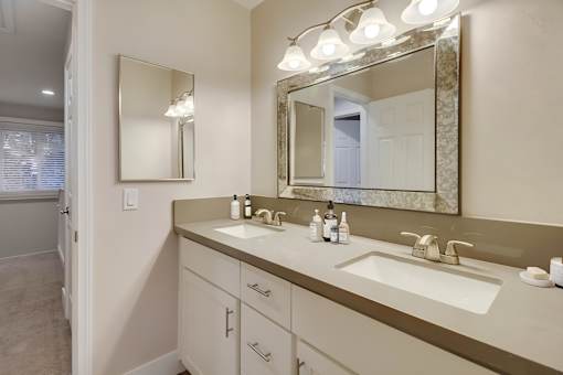 A bathroom with a sink, mirror, and lights.