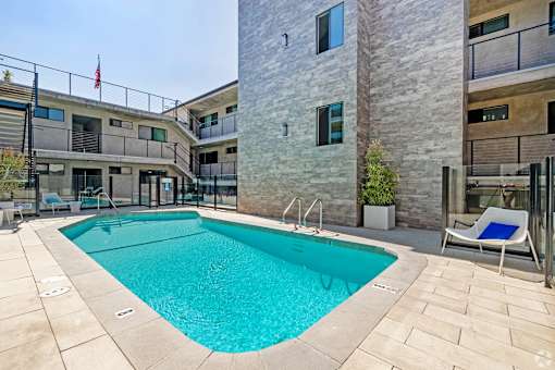 A swimming pool in a courtyard surrounded by buildings.