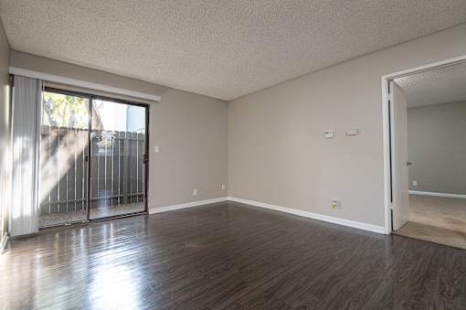 A room with wooden floors and a sliding glass door.