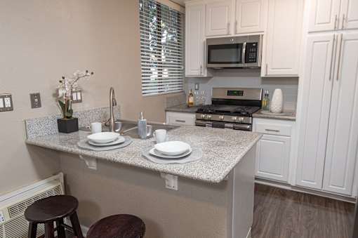 A kitchen with a countertop, stove, and cabinets.