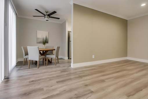 A room with a dining table and chairs.